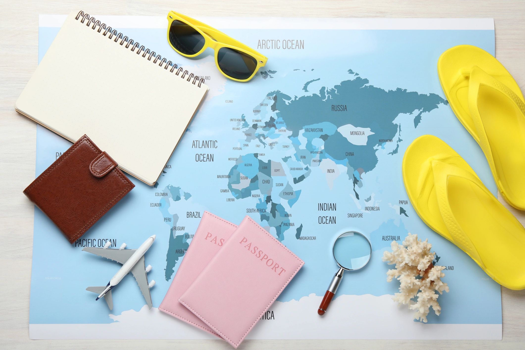Travel planning essentials on a desk with a world map and passports